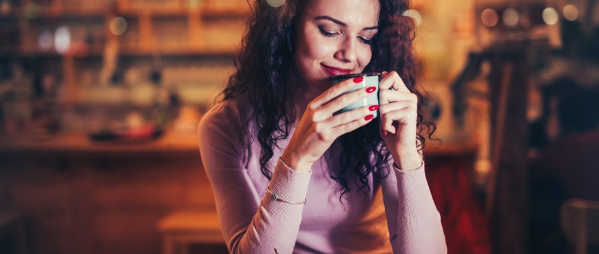Beautiful woman enjoying aromatic coffee