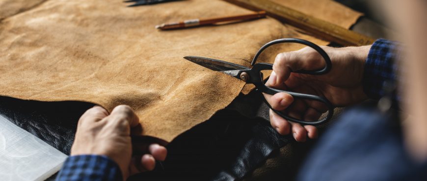 Closeup of craftsman cutting leather handicraft