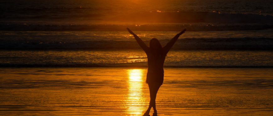 Silhouette of a beautiful young woman on a beach in Montanita, Ecuador at sunset